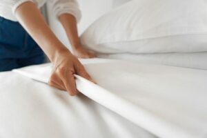 Women pulling back the sheets and her bedding.
