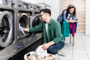 Young couple doing laundry in laundromat