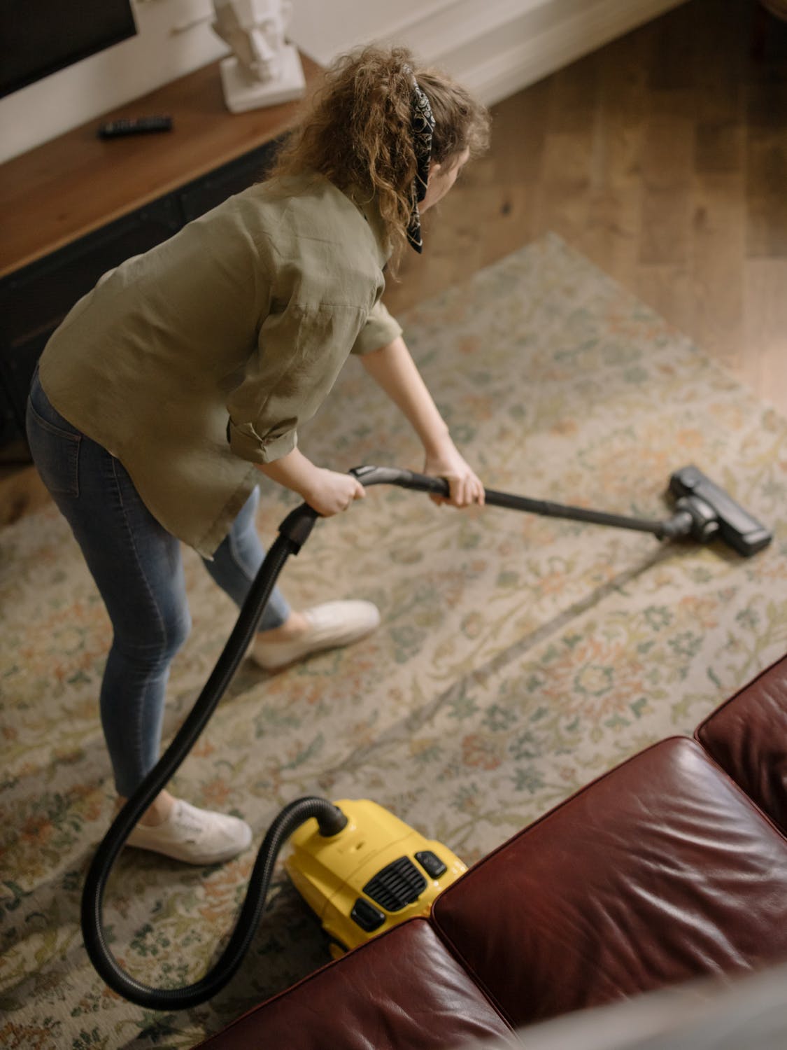 Close up of a woman vacuuming a carpet