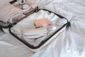 Suitcase on bed packed with clothing