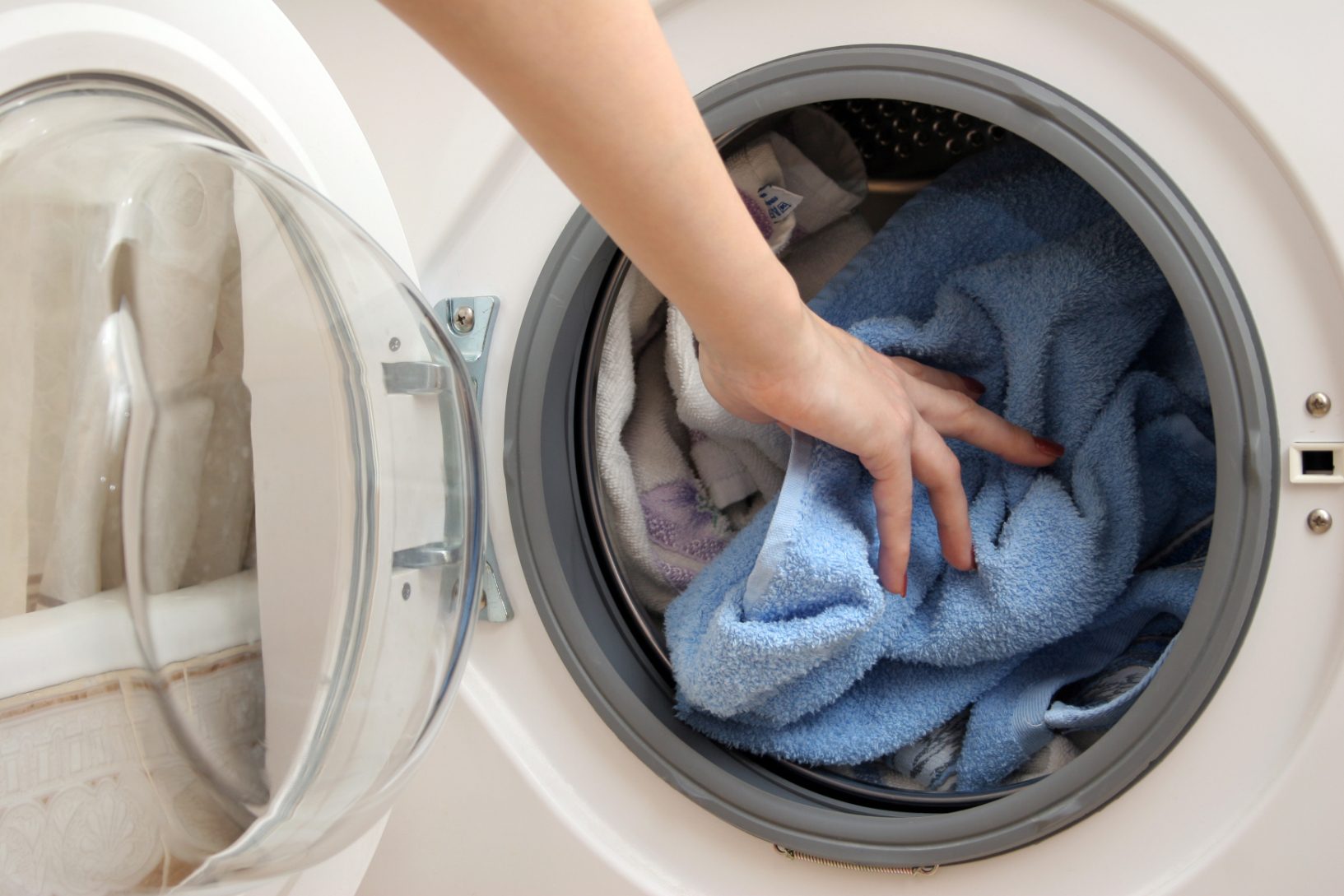 Person putting laundry into a washing machine