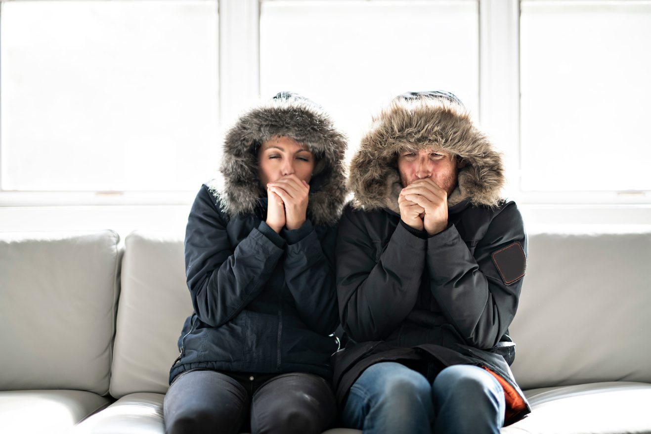 Couple sitting on a couch in coats